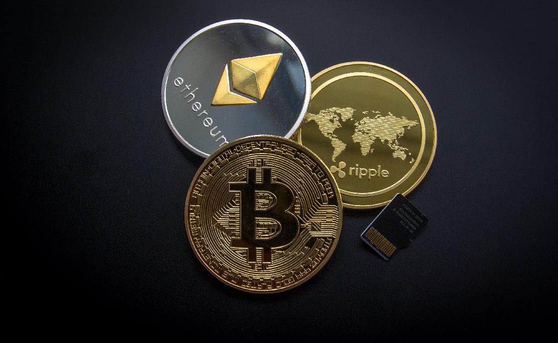 bitcoin ether xrp érme egy fekete háttérrel.